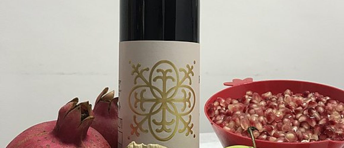 Rosh Hashanah symbols: a bottle of wine, a shofar, pomegranates, apples and honey
